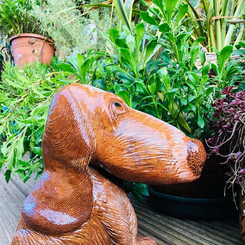 A brown dog sculpture with a long happy nose.