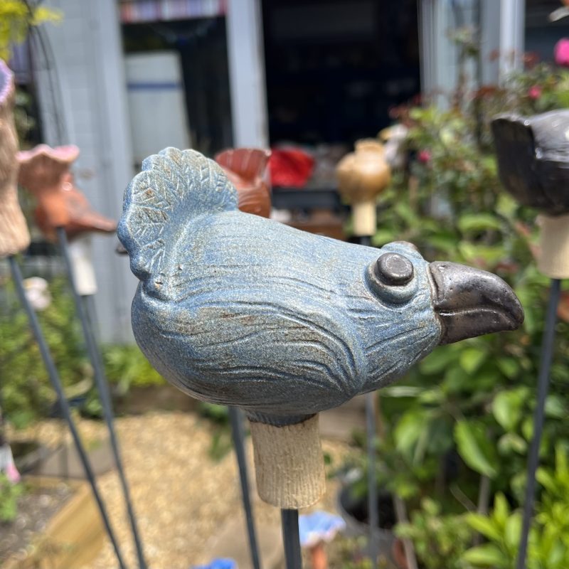 A Ceramic happy bird garden sculpture in the garden.