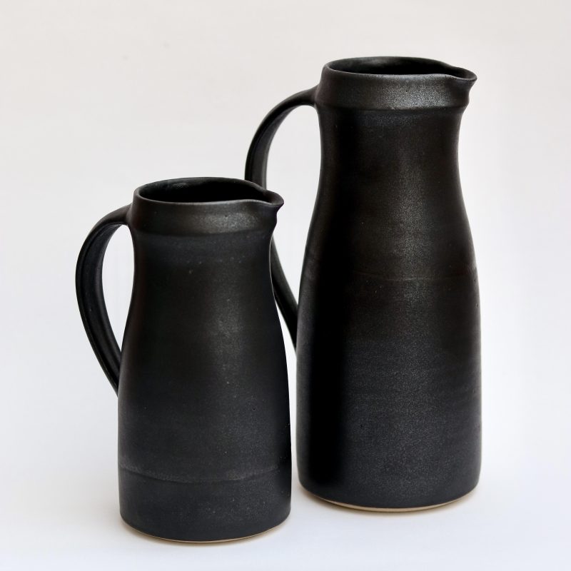 A photograph of two black anthracite jugs