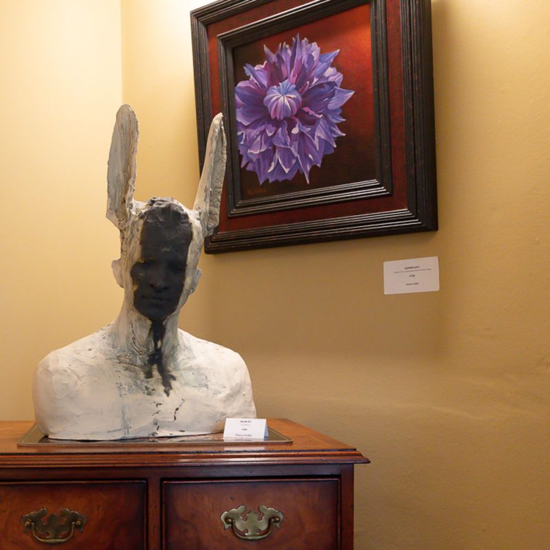 A picture of the sitting room at Art in Bloom showing a selection of paintings and sculptures