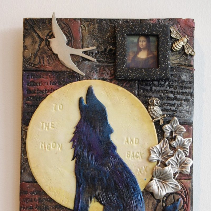 Ceramic frame with a howling wolf image and moon.