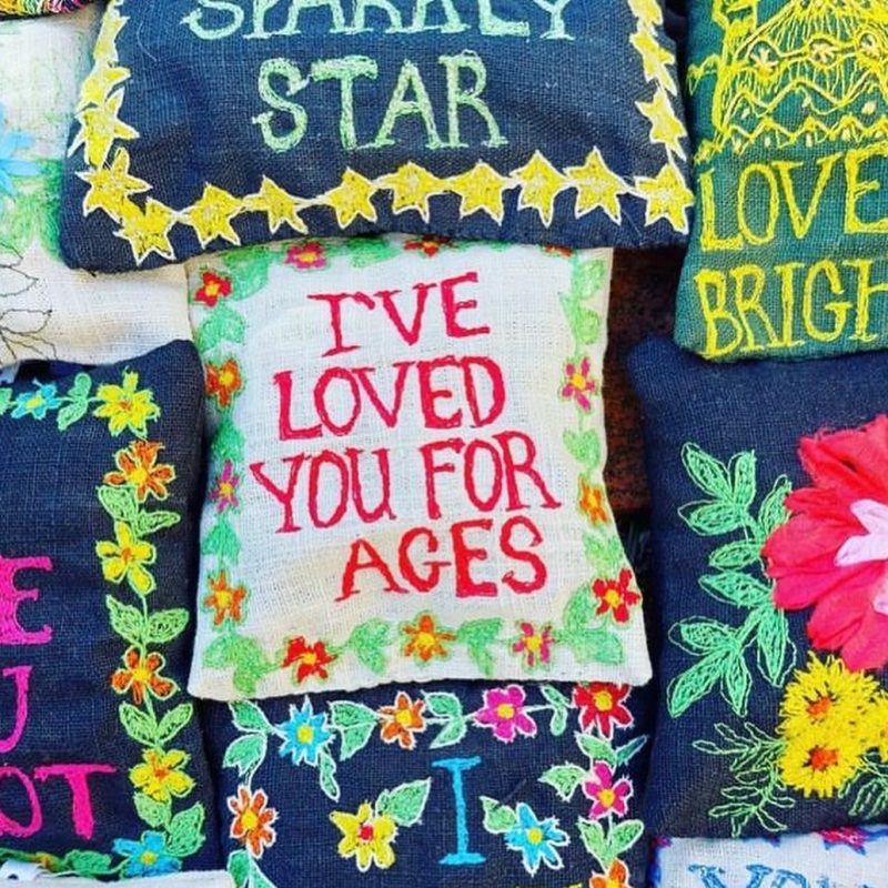 Selection of handmade and embroidered lavender bags with nice messages on them.