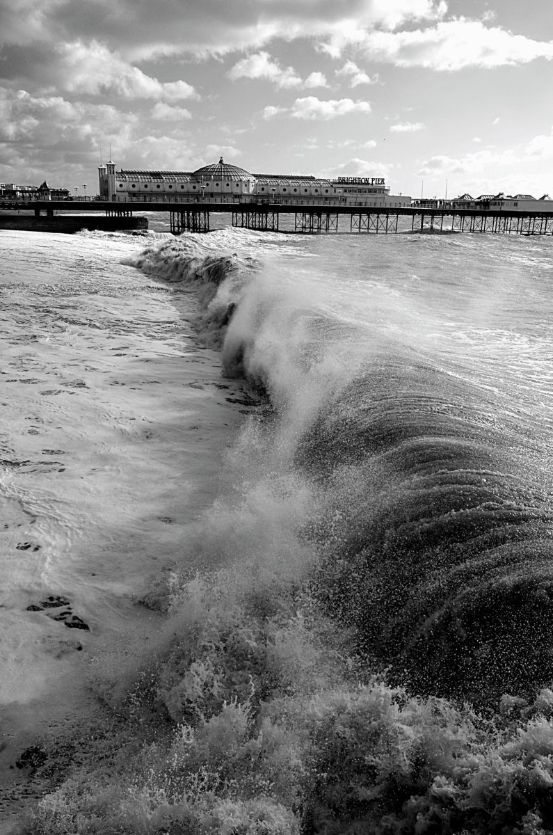 Rolling waves batttering Brighton beach with the Palace pier in the background