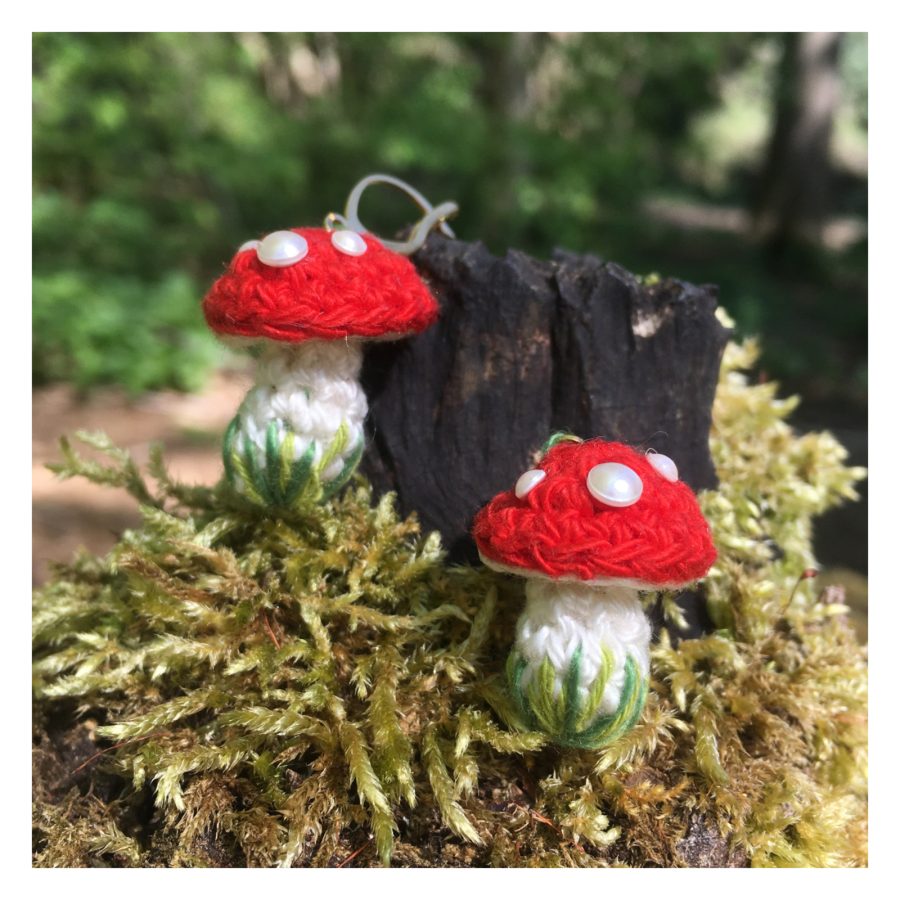 A photographic image of a landscape with crochet mushrooms in the centre