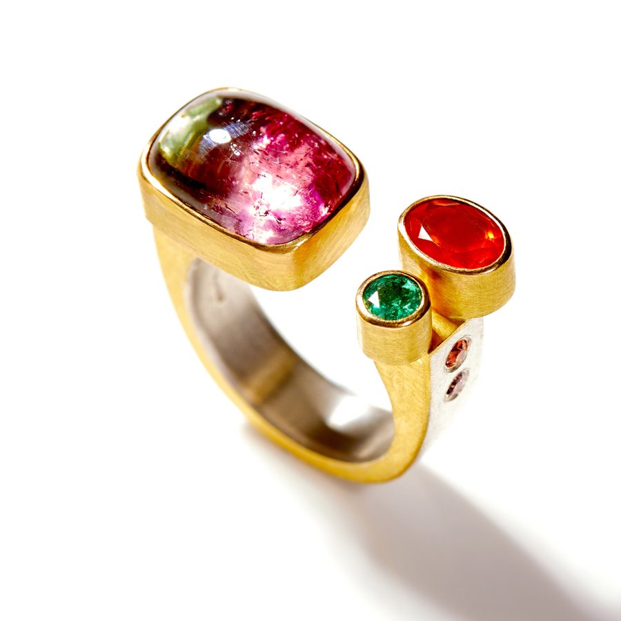 A silver and gold ring with precious stone inset