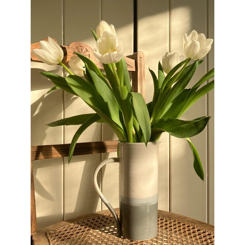 Tall two-tone white and grey gloss straight sided jug holding white tulips