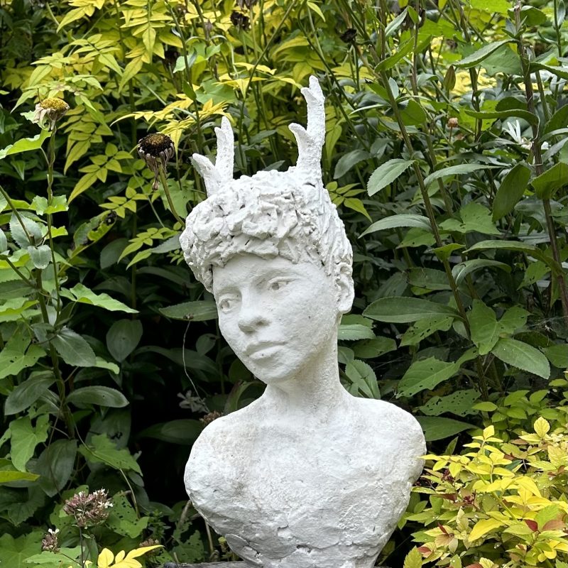 White Wood Nymph sculpture with wooded background