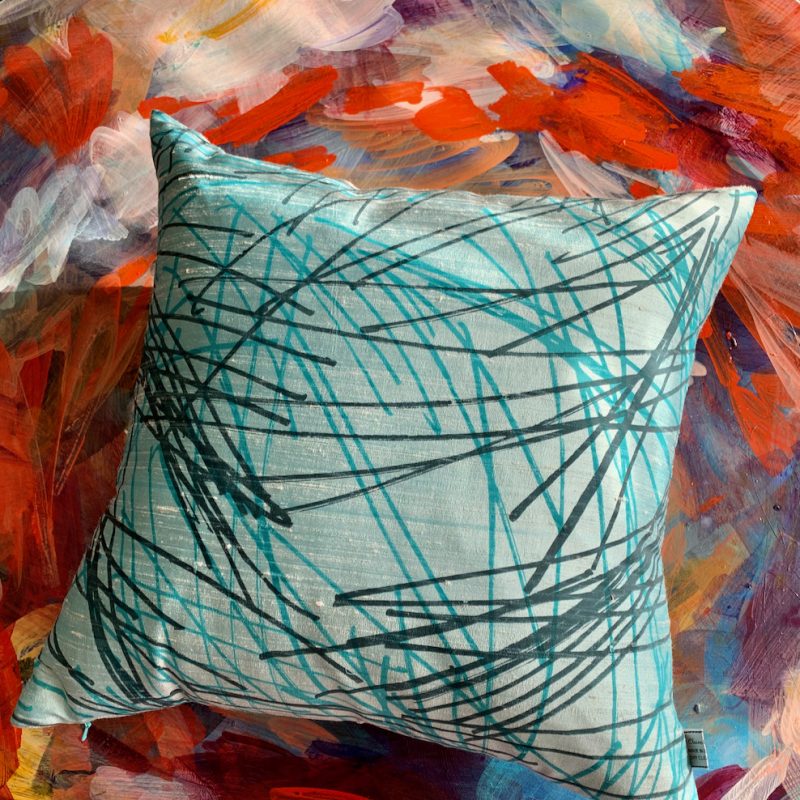 Handprinted silk square cushion in blue with multi directional design.