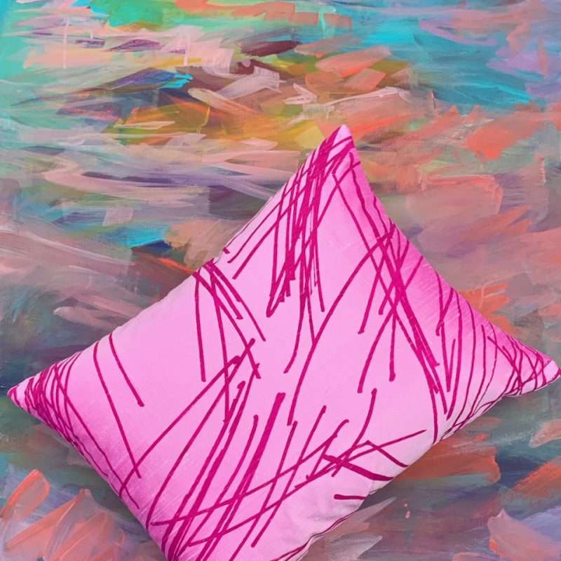 Magenta pink silk cushion with multi directional design.