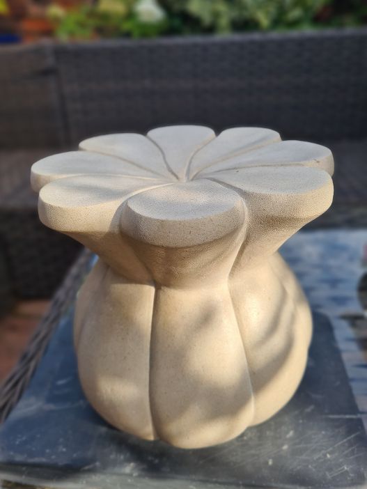 An organic curved shape hand carved from Portland Stone 