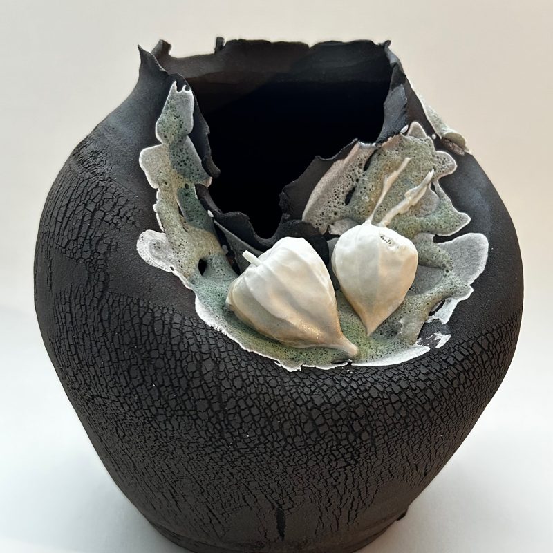 Sculptural black clay vessel depicting earth with additions of porcelain Chinese Lanterns, a symbol of protection.