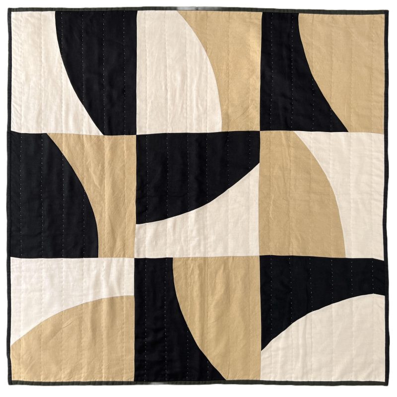 A square handstitched patchwork linen quilt