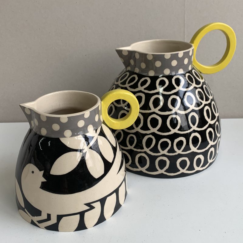 Two ceramic jugs with patterns of birds and patterns