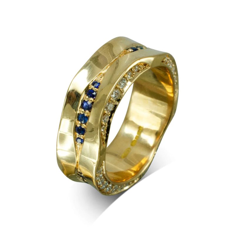 An 18mm wide side-hammered band with diamonds set into it's undulating edges, and row of sapphires set onto the surface.