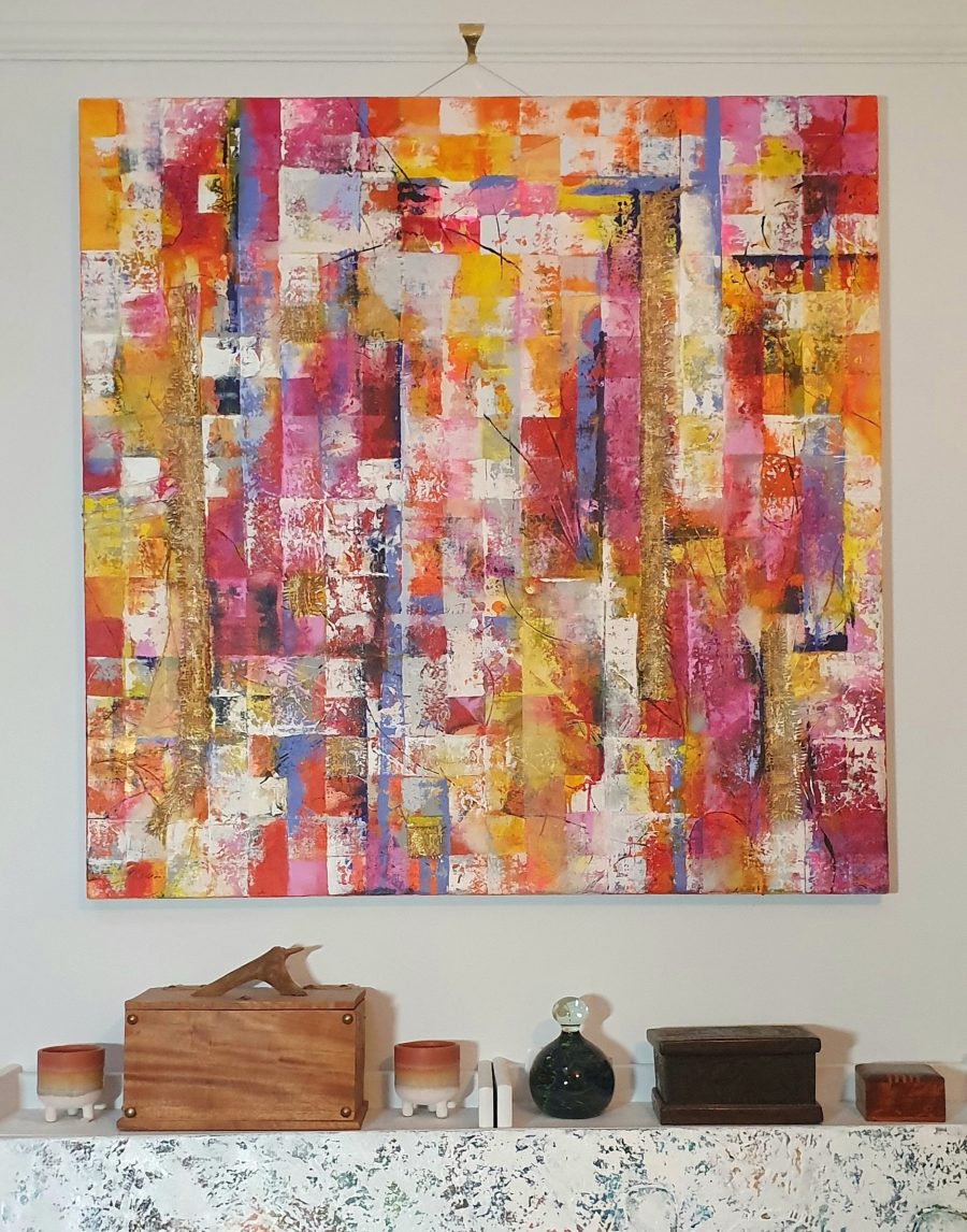 Large multi colours painting hung on the wall. textured and multi coloured.