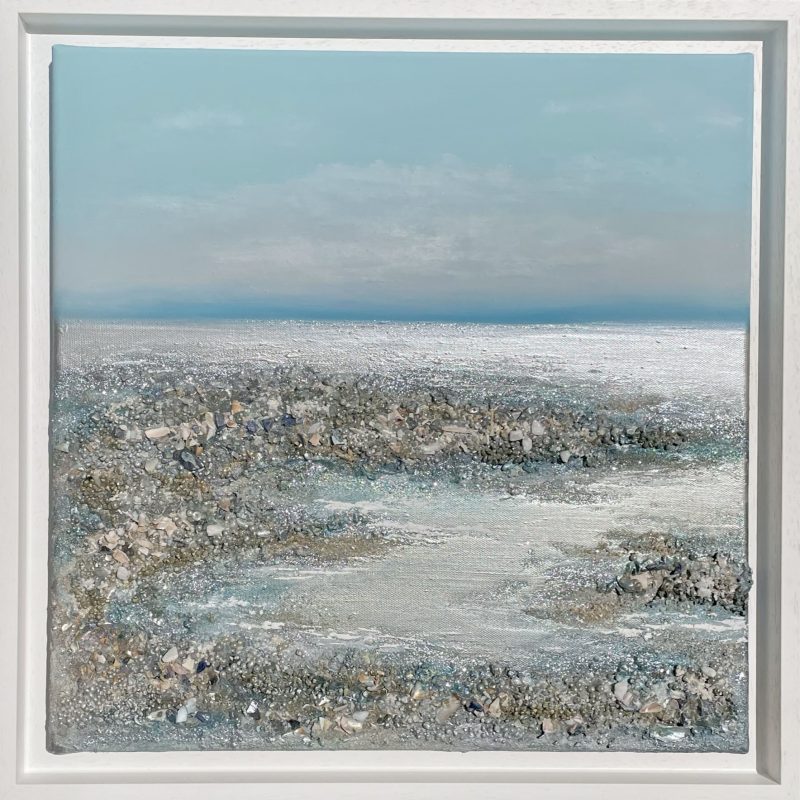 A textural and shimmering bay scene created with beach-combed materials, with calm blue sky and shining silver seas. A peaceful and sunny day by the coast, and the sea is gently making its way out to reveal glittering rock pools. With real Swarovski crystals which glint at you from across the room. The artwork uses white and clear crystal gemstones. 