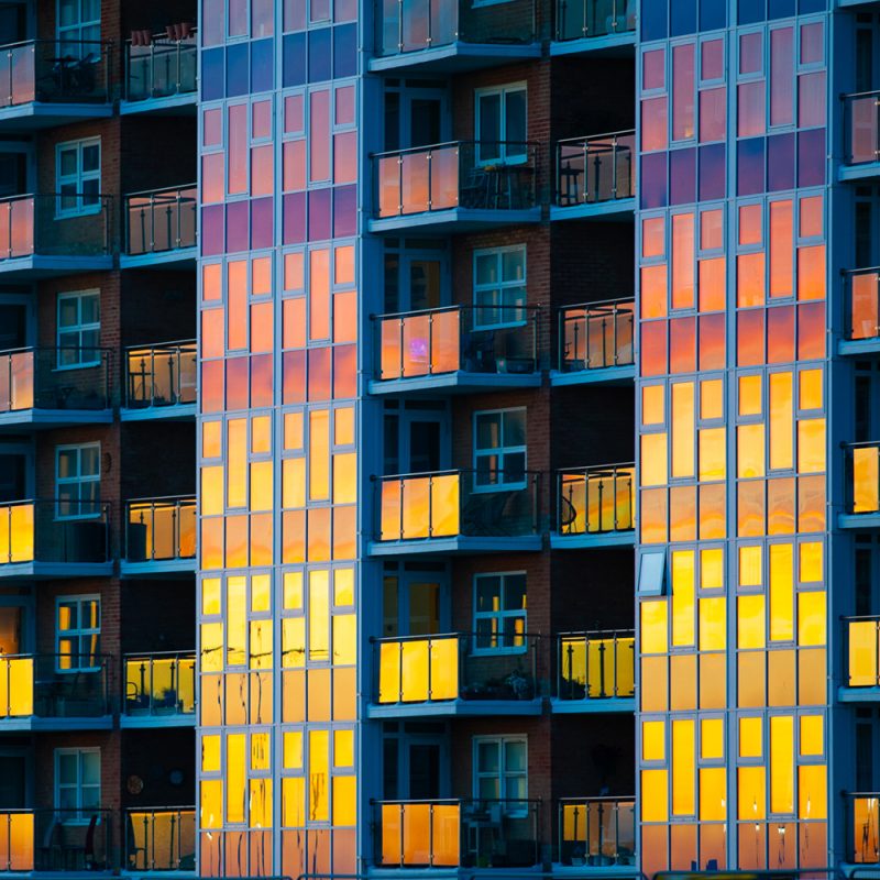 Block of flat on the KIngsway, Hove with the setting sun reflected in the window panes, like a colour palette.