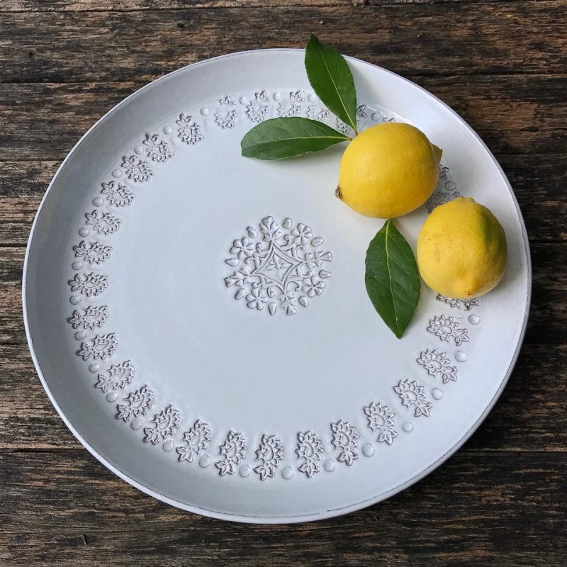 Terracotta wheel thrown plate, hand decorated, finished in white glaze