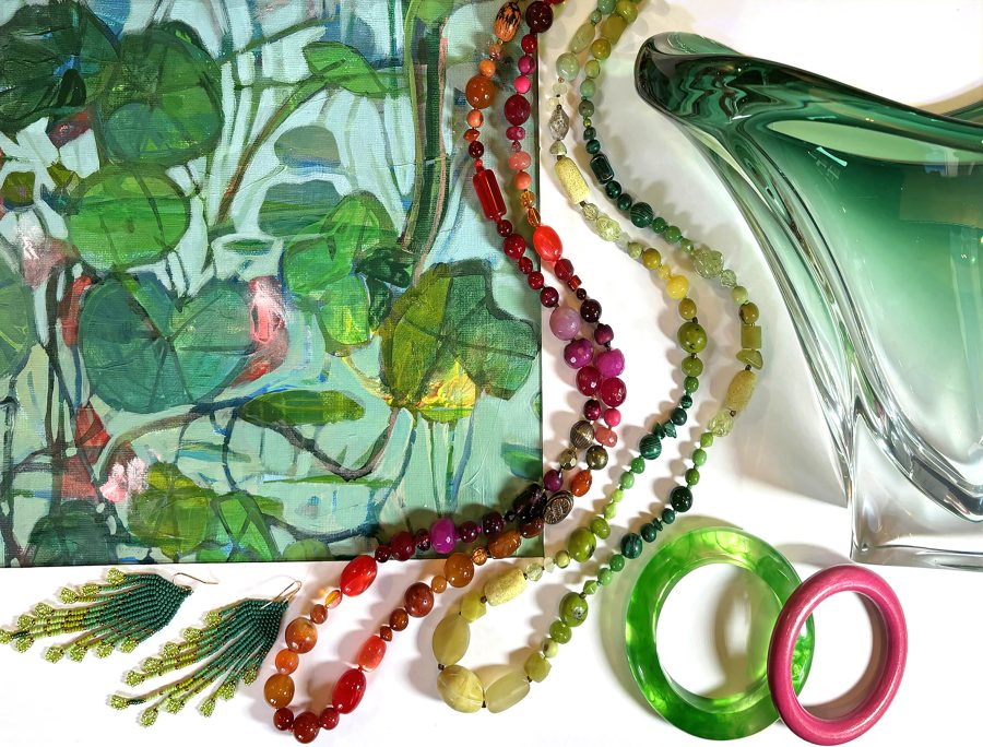A section of a brightly coloured painting with coordinating beaded necklaces, bangles, earrings and glass vase.