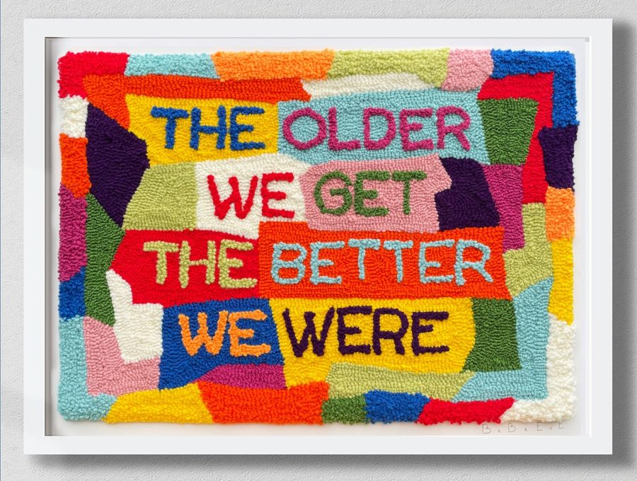 colourful tufted wool on a monks cloth backing, with the text 'The older we get the better we were'