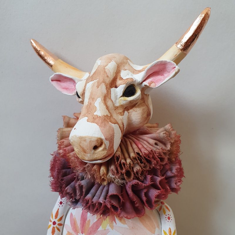 Cow has a sculpted Japanese paperclay head and hooves, with a cloth body. Her legs are articulated and attached with nuts and bolts. She is decorated with water colour paint.