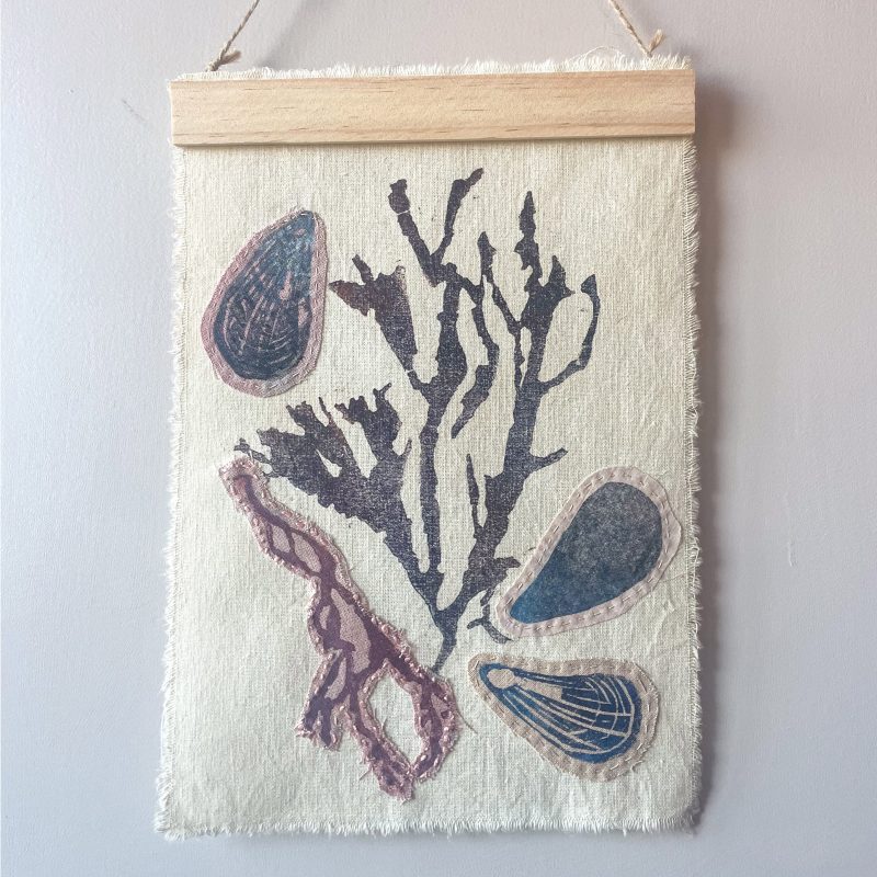 Seaweed and mussel embroidered lino print on linen