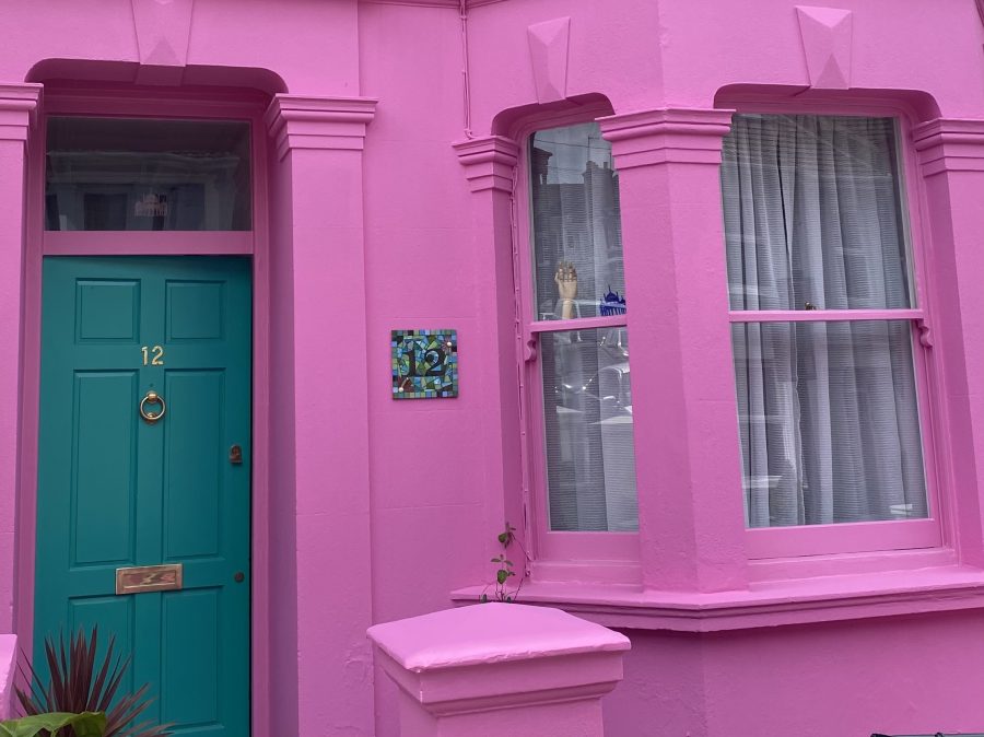 A photograph of a bright pink terraced house. 