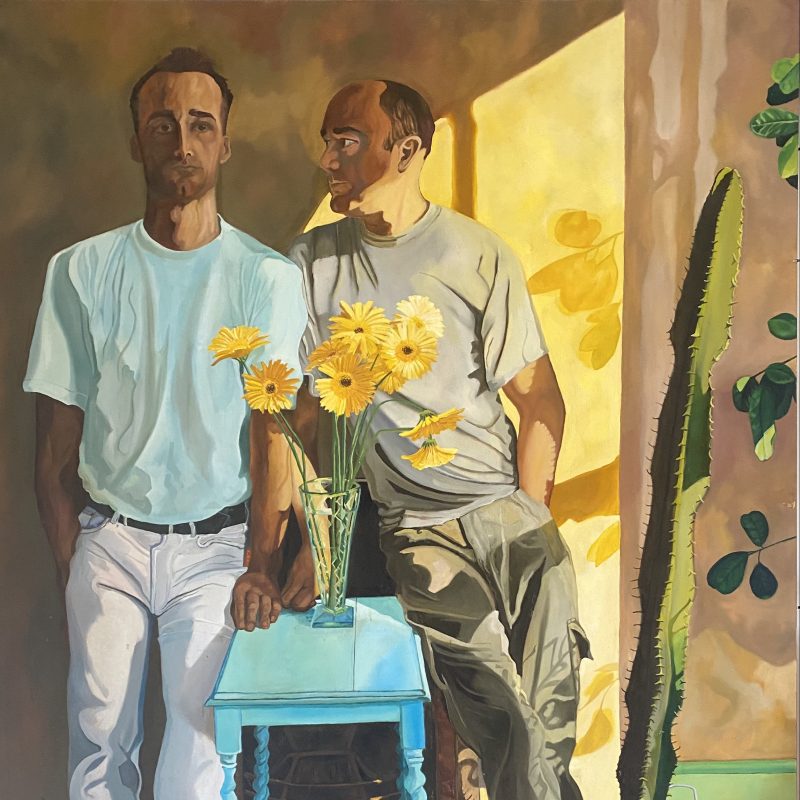 This is a portrait of two men, one is looking at the other. Between them is a table with a vase of flowers; there is also a large cactus