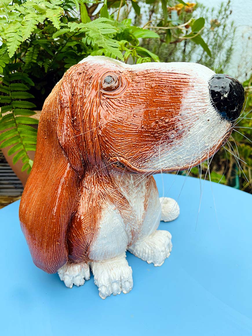 Morris the dog hand sculpted out of clay. Sitting in the garden smelling the flowers.