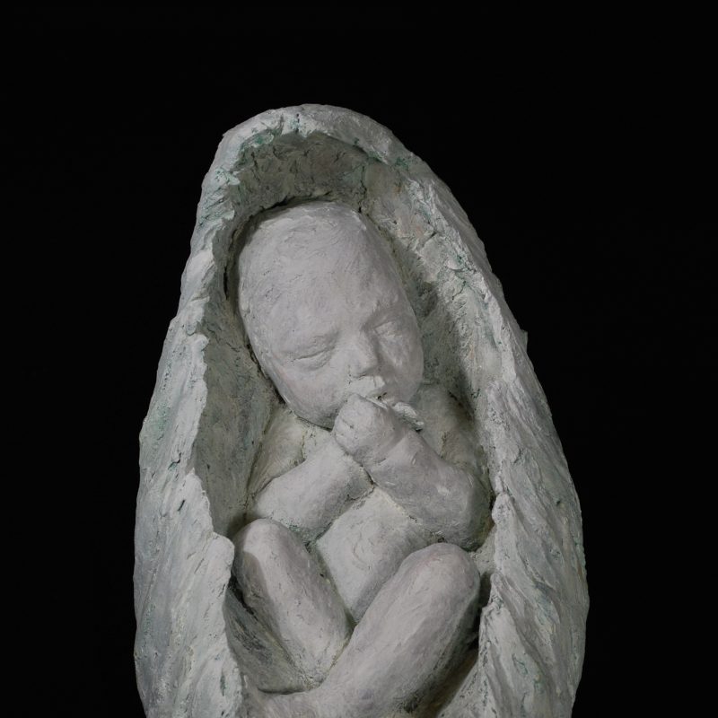 A sculpture of a baby, nestled and resting