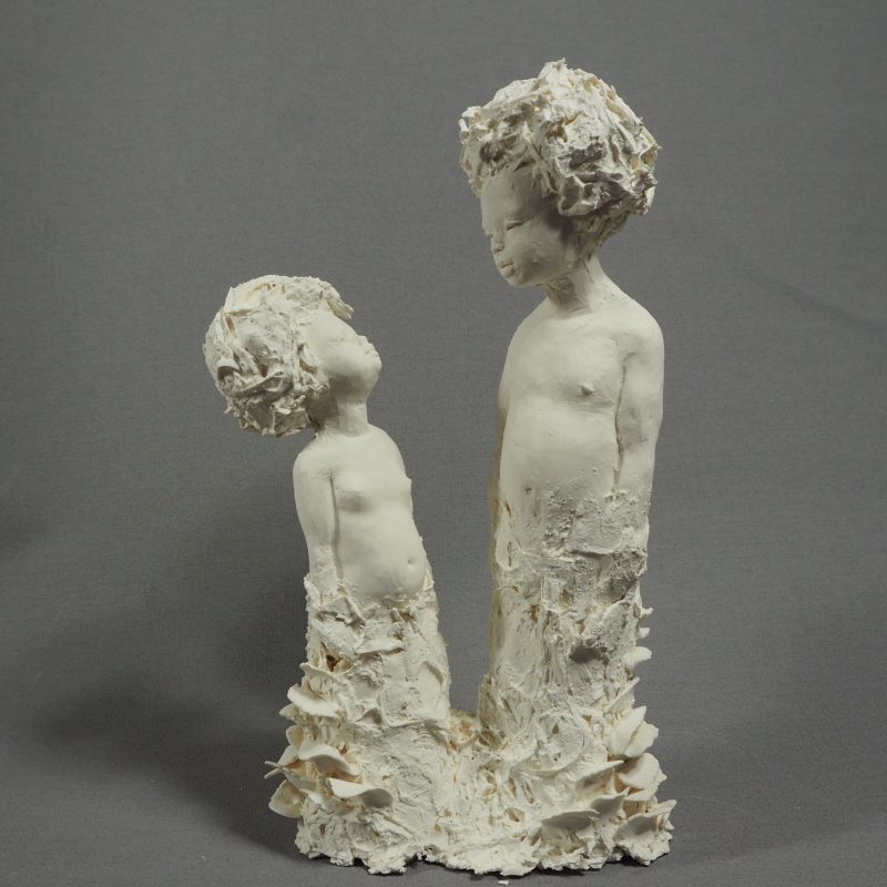 Small white sculpture of 2 children
