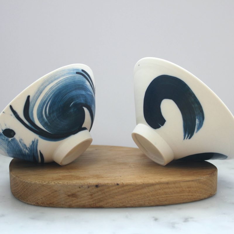 Two delicate white bowls with swirling cobalt colours