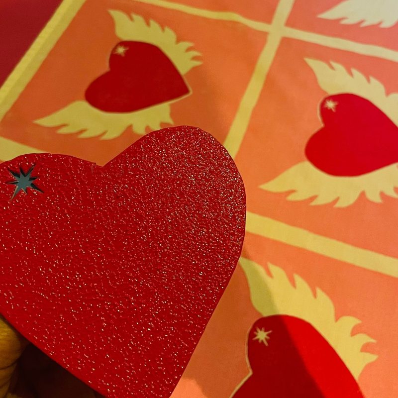 Bold printed red hearts with wings