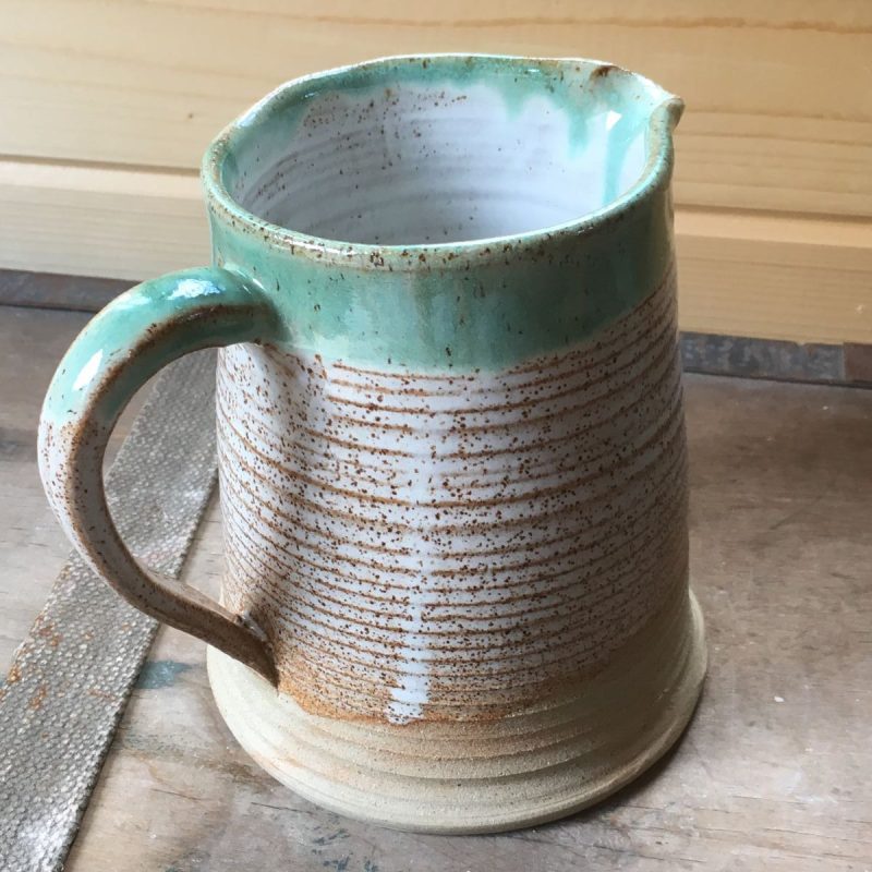 Jug with speckle textured pattern and dipped in green