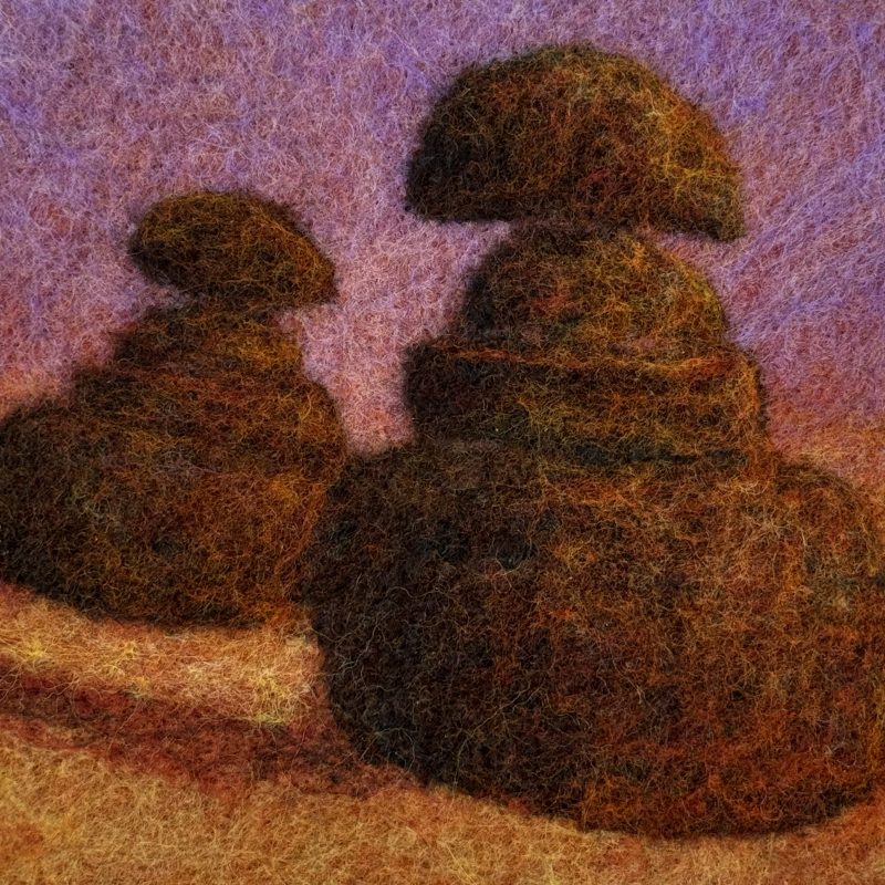 Felted wool image of topiary in a meadow. The sky is purple and the grass is orange. 
