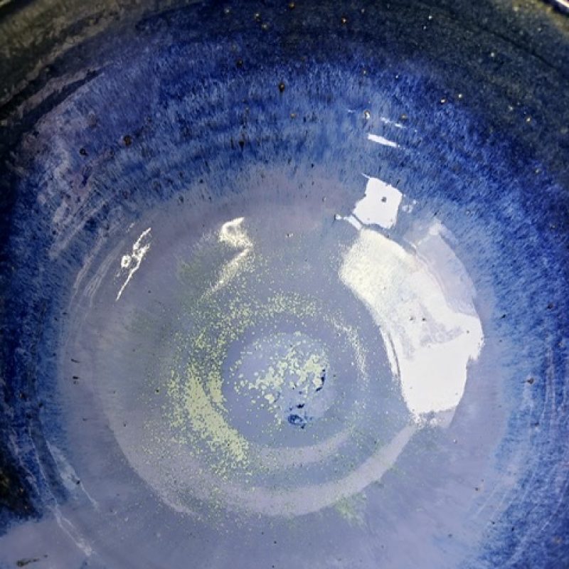 Close up image of large blue glazed bowl showing the detail of the copper