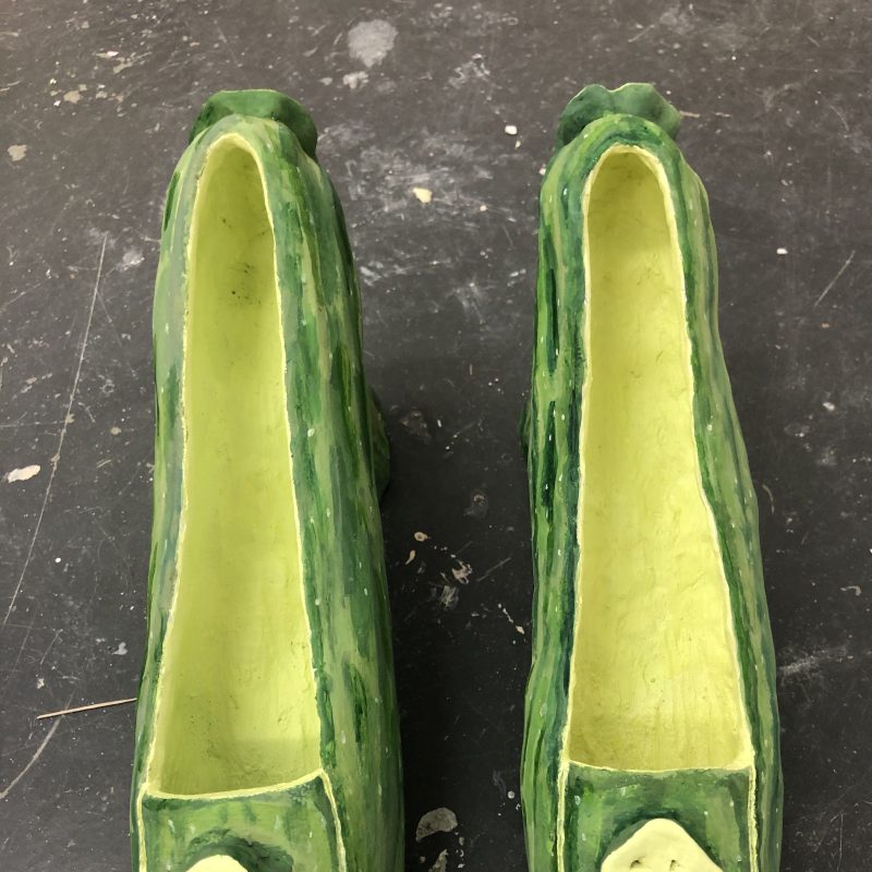 A pair of ladies high heel shoes made out of courgettes, but really they are made of pottery