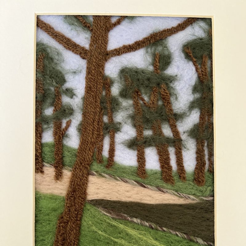 Textured needlefelt image of brown tree trunks on a path