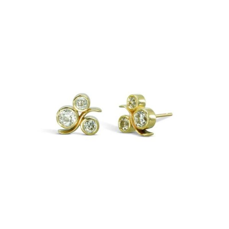 Gold earrings consisting of three round diamonds with a curved gold wave crossing through them