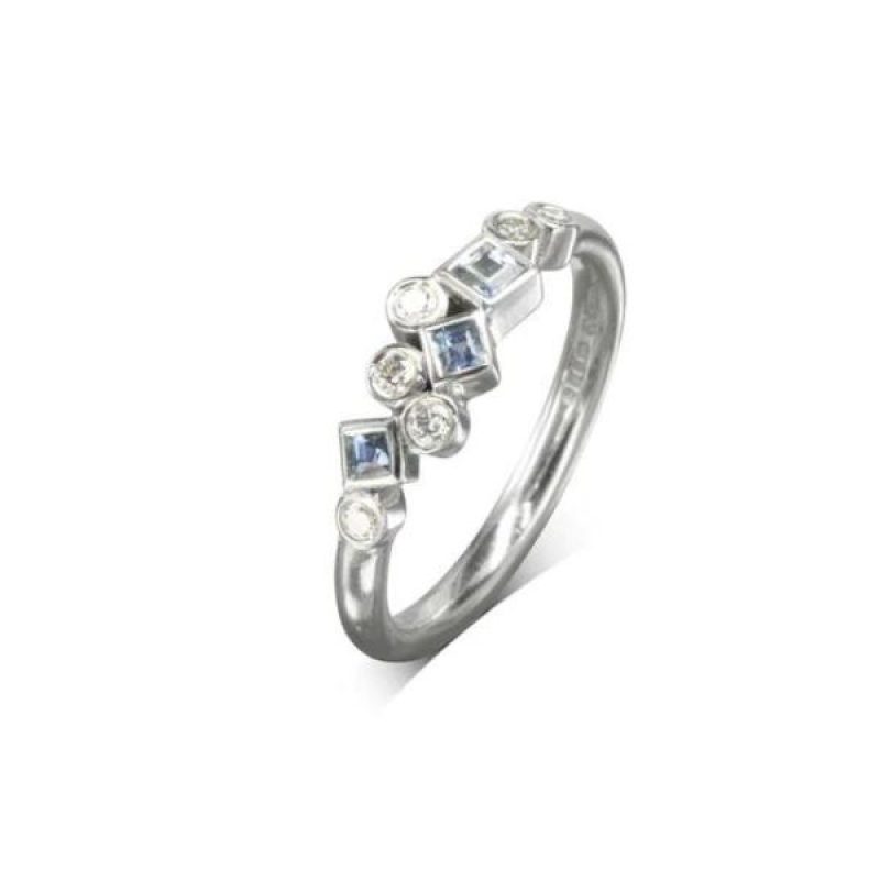 A white gold ring with round diamonds and square aquamarines clustered along the front of the band.