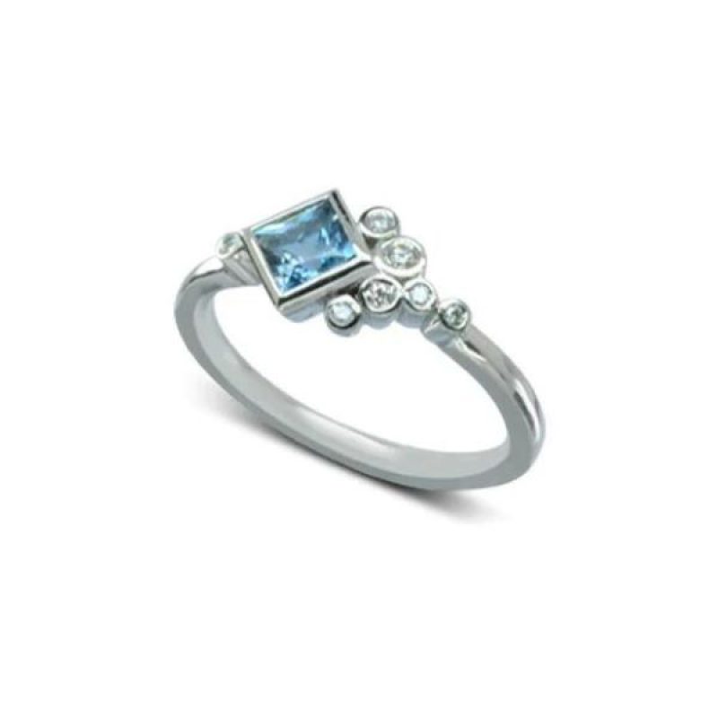 A white gold ring featuring a square light blue gemstone and multiple small round diamonds arranged asymmetrically on the band.