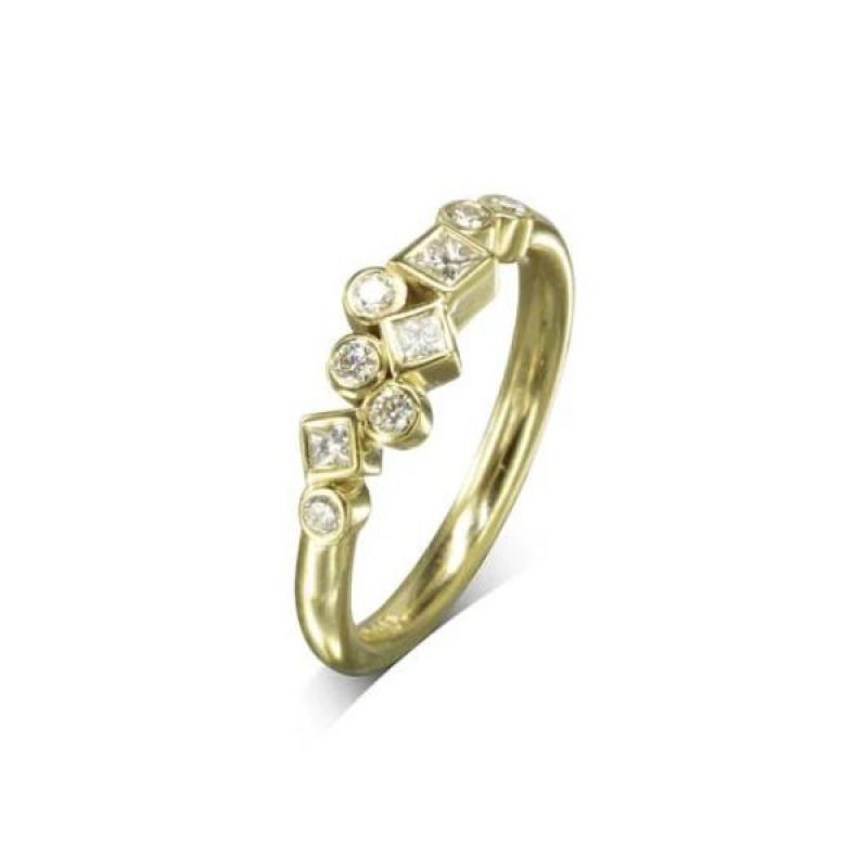 A yellow gold ring with round and square diamonds clustered along the front of the band.