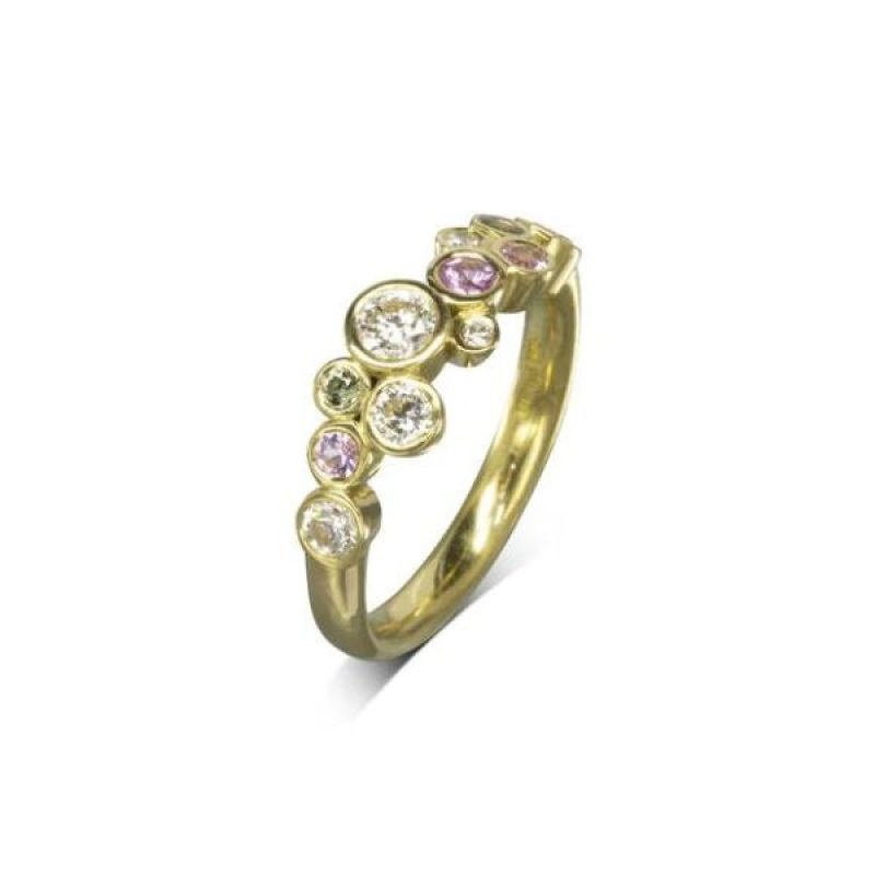 A yellow gold ring with round diamonds and pink and green sapphires clustered along the front of the band.