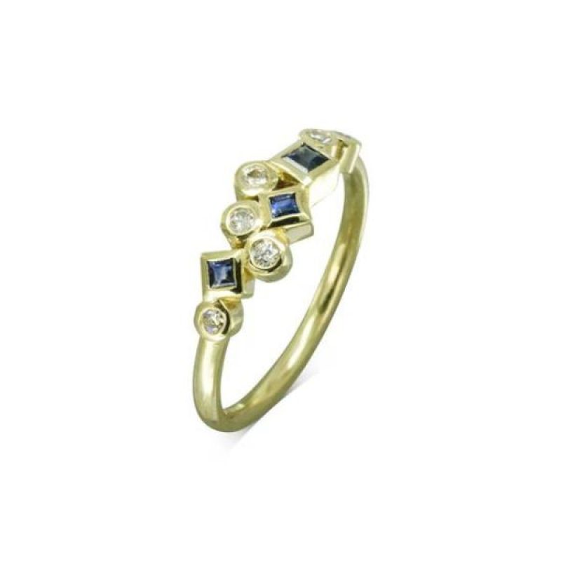 A yellow gold ring with round diamonds and square blue sapphires clustered along the front of the band.