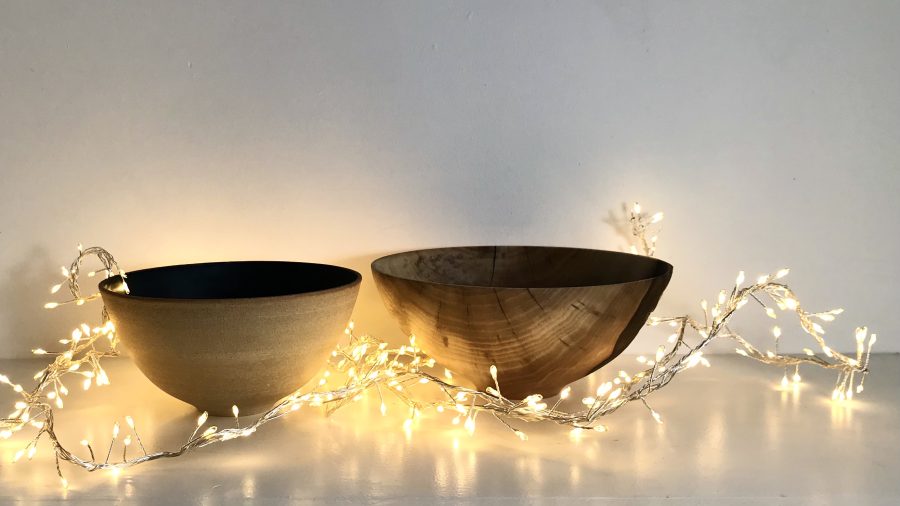 Ceramic and wood bowls among a nest of fairy lights