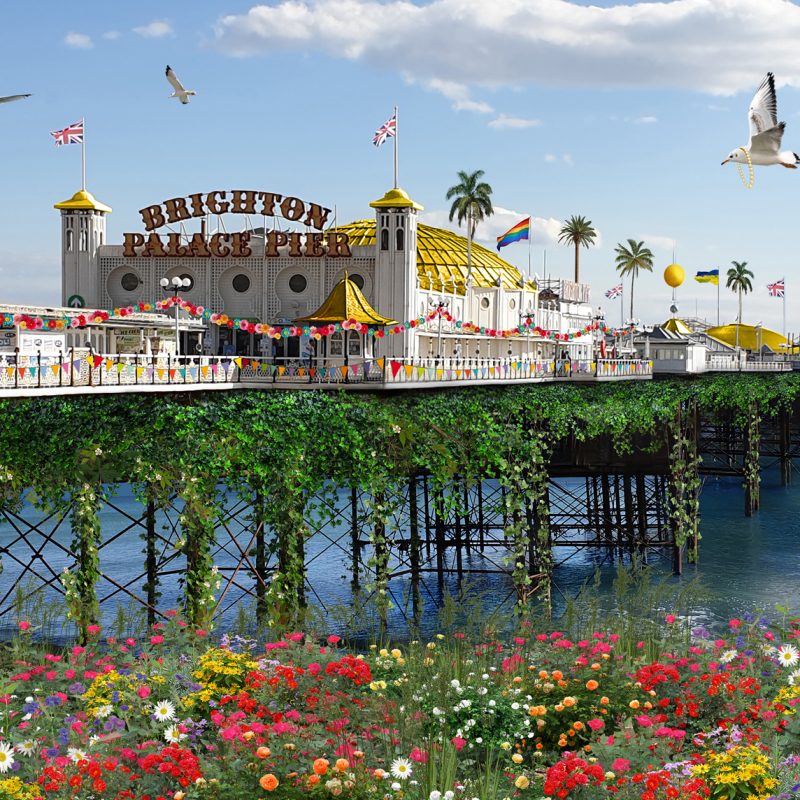 Brighton Palace Pier with flower beds, flags, palm trees, seagulls and dolphins