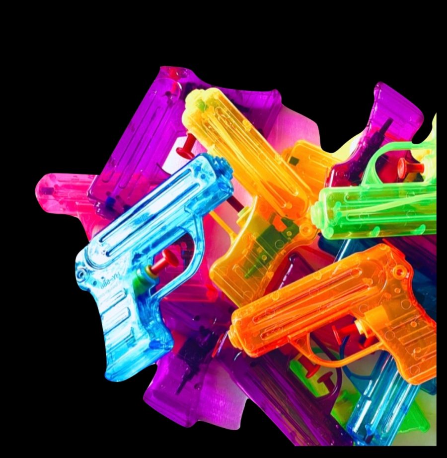 A bright attention grabbing photograph of multiple brightly coloured plastic water pistols, randomly piled up on a black background. 