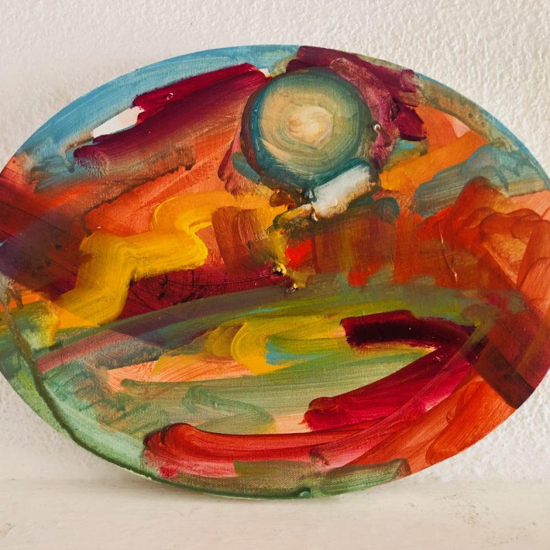 An oval painting of a glorious sunset.