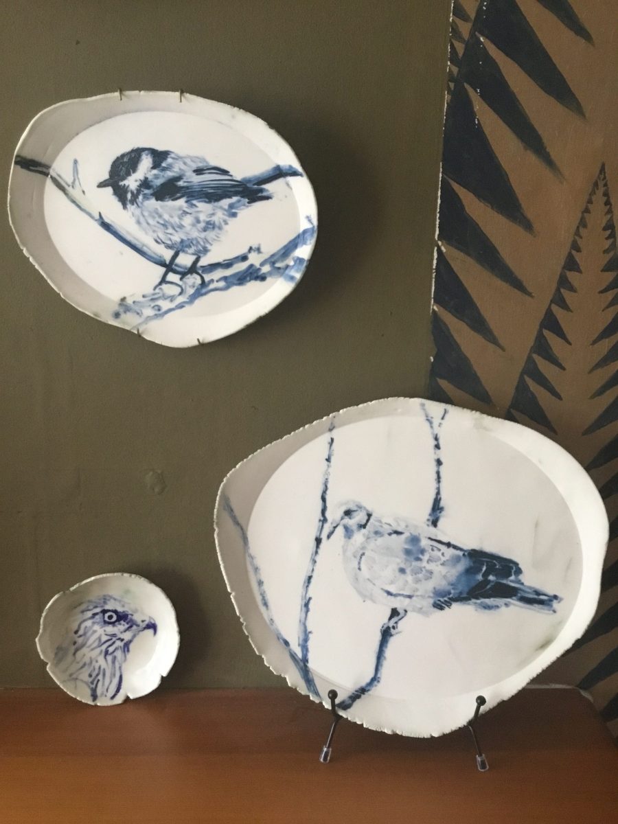 Two oval vitrified porcelain plates and a small bowl painted in blue cobalt oxide with two Ronins on a branch. 