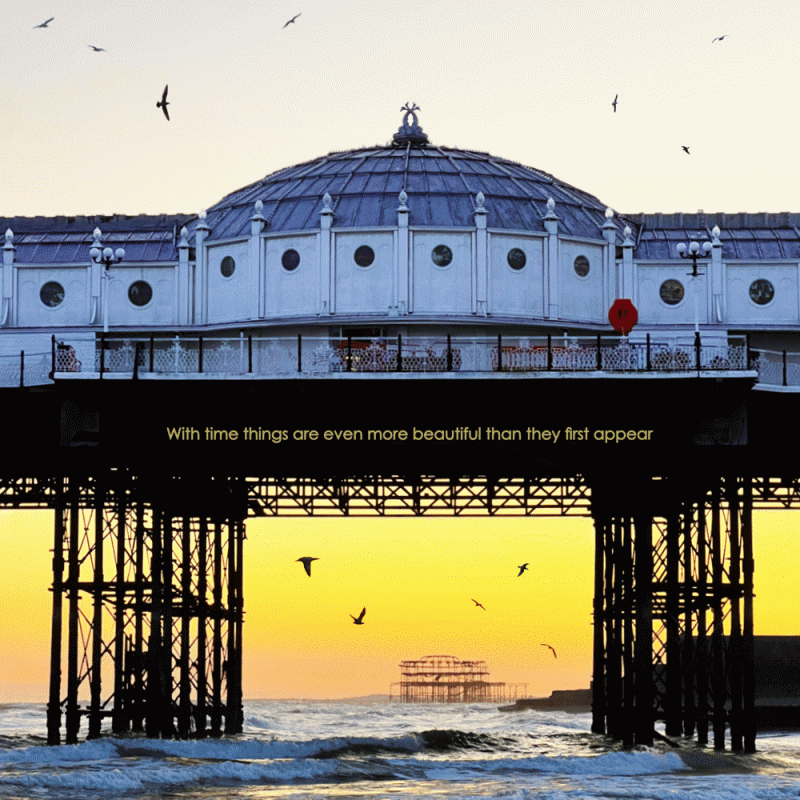 Beautiful photograph of West Pier framed by Brighton Pier at sunset